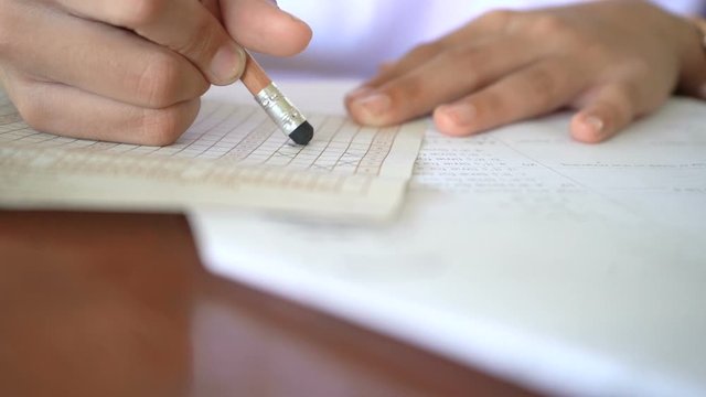 Students who are testing their knowledge by doing tests, Slow motion concept. The wrong cross and has been deleted to correct in the correct order.
