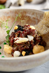 Beef tartar in beige ceramic bowl