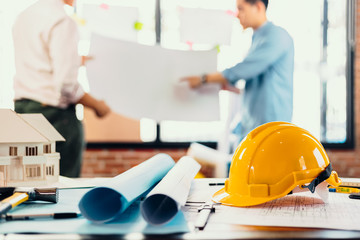 safety helmets  on the table at site construction. Architect, Engineer and businessman  read  planning background.