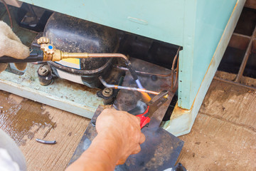 repair old refrigerator job,technician welding copper pipe by gas before vacuum system at...