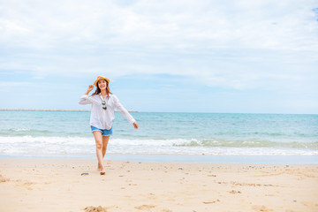 Happy young girl walking on the beach. Summer travel, vocation, holiday concept.