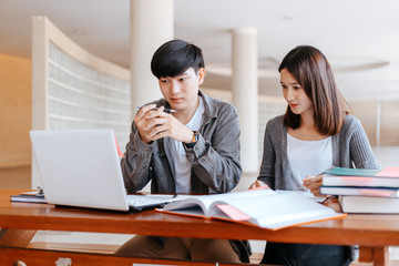 High school or college students  group catching up workbook and learning tutoring on desk and reading, doing homework, lesson practice preparing exam.