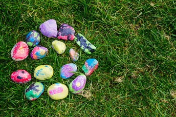 Rocks painted by a child with bright colors; painted rocks arranged in a circle
