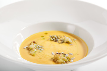 Pumpkin soup in white bowl
