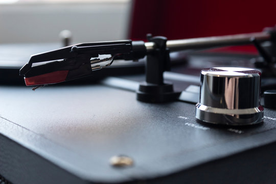 Closeup to a red turntable needle with turntable buttoms. Music lovers and retro concept