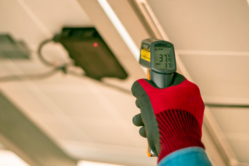 Engineering used an infrared thermometer to measure the temperature of junction box in solar panel...