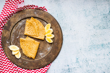 Folded crepes or pancakes with banana fruits. Vegan sweet dessert food.