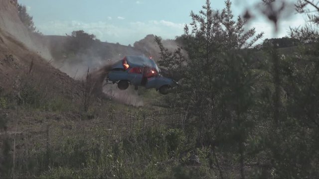 An old Moskvich car, burns and extremely flies off a cliff, making a somersault completely crash.