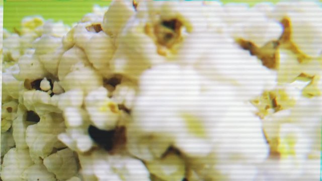Airy salty popcorn. Tossing popcorn into a bowl. Vhs noise. Distortion, glitch effect. 4K.
