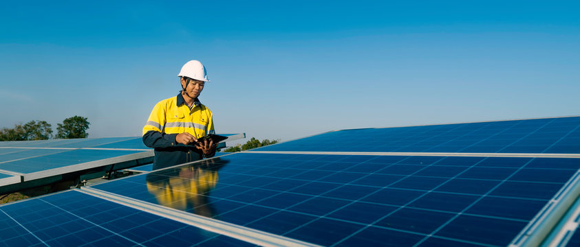 The solar farm(solar panel) with two engineers walk to check the operation of the system, Alternative energy to conserve the world's energy, Photovoltaic module idea for clean energy production