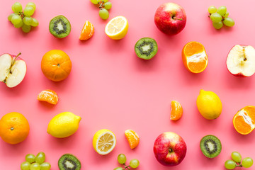 Fototapeta na wymiar Colorful fruit mockup. Cut apple, kiwi, citrus on pink background top-down copy space