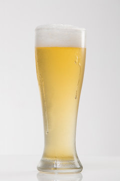 Light Pilsner Beer in Tall Ice-cold Glass with Head - Photographed on White in Studio