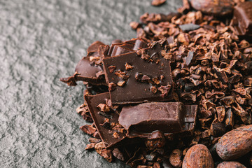 Dark chocolate pieces crushed and cocoa beans, top view