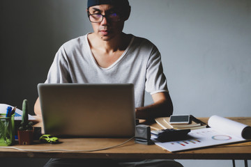 Asian man working from hone online because of covid-19. Work at home and social distancing concept. Selective focus.