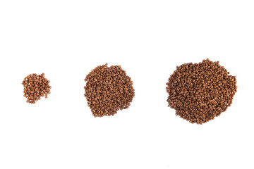 Three heaps of buckwheat. Buckwheat groats on a white isolated background.