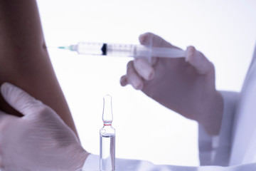 vaccination of person with ampule in foreground health concept