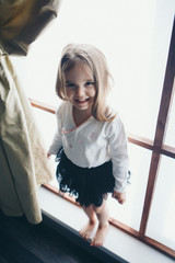 girl by the window. child looking out. Concept oflife style, holidays