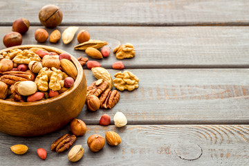 Mixed nuts in bowl - healthy snack - on wooden background copy space