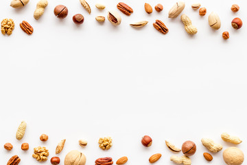 Nuts background - healthy snacks concept - on white table top-down frame copy space