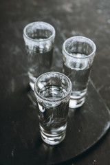 Tequila shots on the dark rustic background. Selective focus. Shallow depth of field.