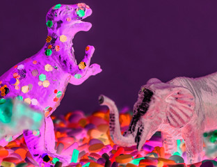 Close up of dinosaurs and animal figure toys on sweet candy sprinkles