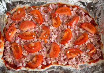 preparation for pizza with cheese and tomatoes
