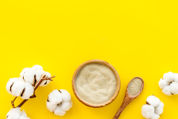 White cosmetic clay on yellow background top-down copy space