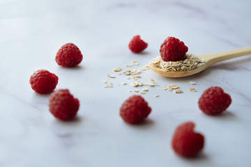 Healthy breakfast, close-up of spoon with oatmeal and raspberry 