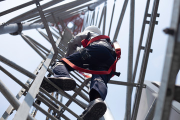 Engineer wear safety equipment climb high telecom tower for maintenance 5G network working 