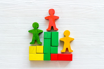 Winners podium. Figures of humans on white wooden background top view