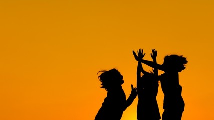 silhouette of a girls jumping enjoying together on sunset time.