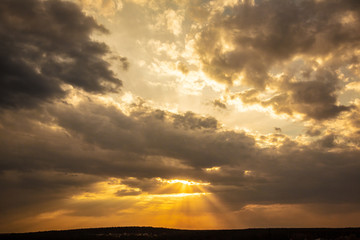 Sunset sky with clouds and sunbeams