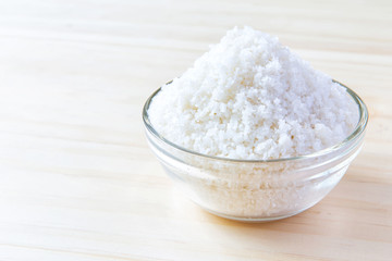 Sea salt in bowl on wooden background, Sea salt is salt that is produced by the evaporation of seawater. Used as a seasoning in foods, cooking, cosmetics and for preserving food..