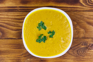 Pumpkin soup on a wooden table. Top view