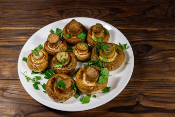 Baked mushrooms in plate on wooden table