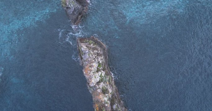 Aerial view over rock needle in Atlantic Ocean, Madeira island. Ilh&eacute;us da Ribeira da Janela. Navigating the sea. Drone view of ocean and rocks.