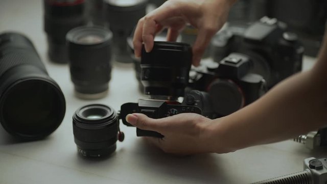 A hand changes the camera lens among other lenses. close up video trading tool