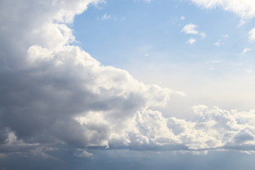 Grey cumulus clouds flies in the sky after rain. A piece of blue sky is visible next to large clouds. Theme of weather forecast.