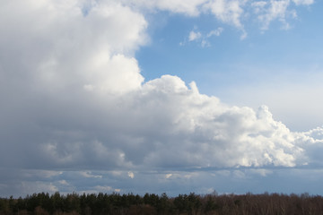 Grey cumulus clouds flies in the sky after rain. A piece of blue sky is visible next to large clouds. Theme of weather forecast.