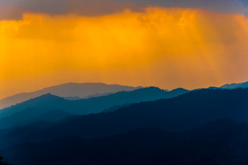 Silhouettes of the mountain hills and forest at sunset.