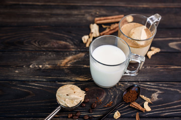 Delicious and fragrant dalgona coffee in glass cups, cinnamon sticks, dried mushrooms, a spoon of instant coffee, sugar. Cooling coffee drink with milk