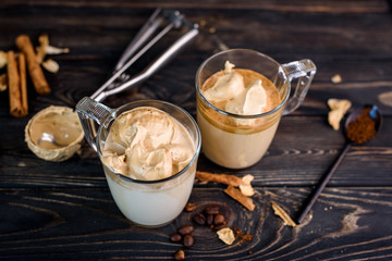 Delicious and fragrant dalgona coffee in glass cups, cinnamon sticks, dried mushrooms, a spoon of instant coffee, sugar. Cooling coffee drink with milk