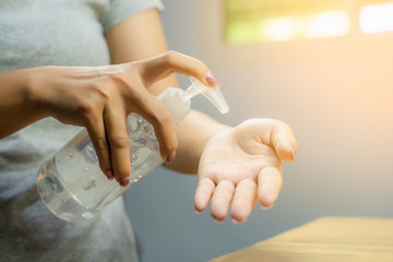 Woman hand using alcohol wash gel for cleaning sanitize gel pump dispenser.