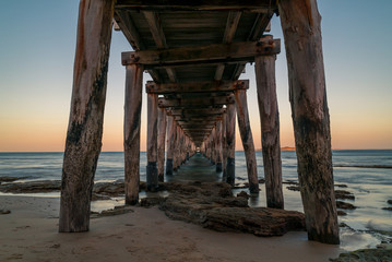 View looking through a jetty out into the ocean at sunset in Queenscliff, Victoria