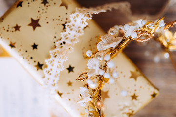 Wedding composition decorated with  gold and pearl jewelry and invitation letter on the wooden table with lace. Jewelry closeup details from morning of the bride.