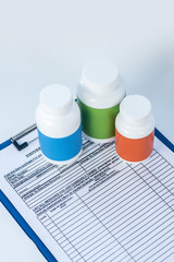 Three bottles of pills on the table on a patient file