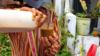 Traditional herbal medicine seller when brewing jaunya drink in a glass, Pekalongan Indonesia