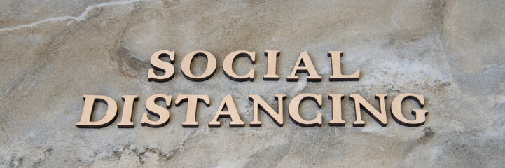 social distancing , writen wooden letters on stone background