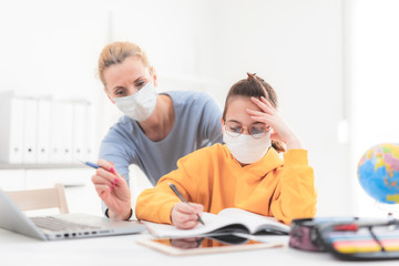 Child home studying education, homeschooling, with private tutor / mother with protective mask in...