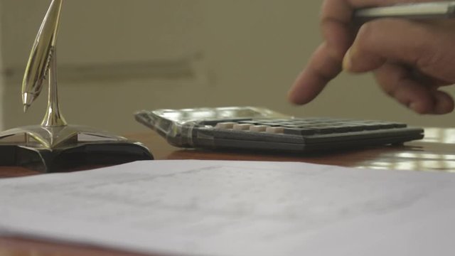 Finger writing doing calculation. Calculating balance Audit or tax report with calculator. Close-up Defocused front Businessman hand checking account in paper pencil. Business finance economy Concept.